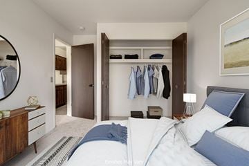 Westland apartment for rent - a bedroom with a large bed and a closet with clothes hanging on the wall