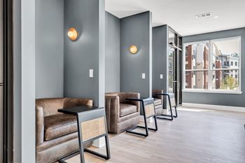 A row of brown leather chairs are lined up in a hallway.