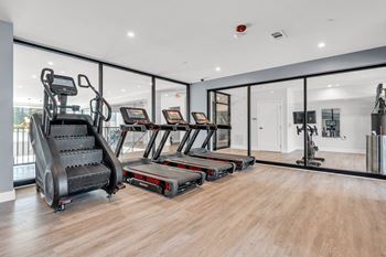 A gym with treadmills, elliptical machines, and a stair climber.
