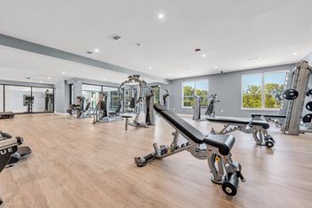 A gym with a variety of equipment including a bench press.