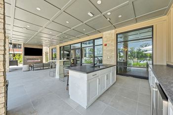 A modern kitchen with a large island and a view of the backyard.