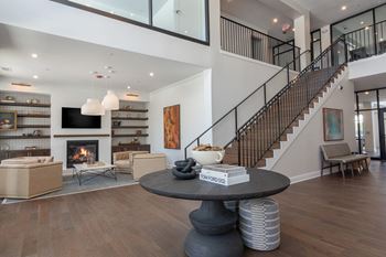 A living room with a fireplace and a staircase.