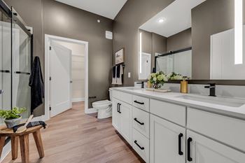 A bathroom with a toilet, sink, and mirror.