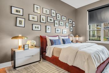 A bedroom with a large bed and a nightstand with a lamp.