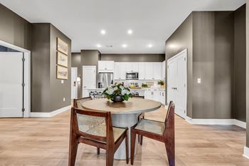 A modern kitchen with a dining table set for two.