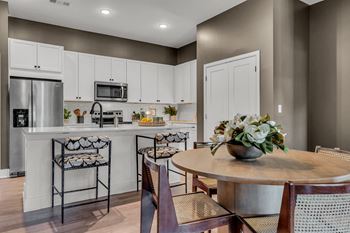 A kitchen with a table and chairs.