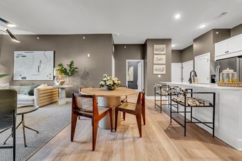 A modern dining room with a wooden table and chairs.