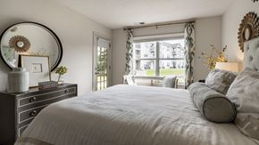 Crown Point apartment for rent - A bedroom with a large bed, a dresser, and a window with curtains at Mallard Bay Apartments, Crown Point, Indiana