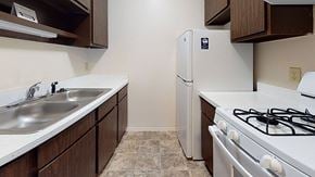 Portage apartment for rent - a gallery-style kitchen with a stove and a refrigerator at Newport Village Apartments, Portage