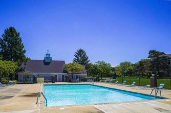 A swimming pool with a house in the background
