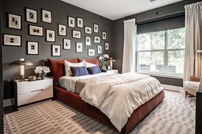 Merrillville apartment for rent - A bedroom with a large bed and a wall of picture frames.