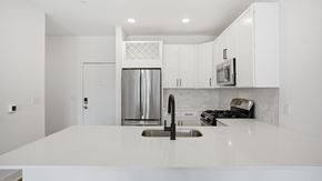 Merrillville apartment for rent - A modern kitchen with white cabinets and appliances at Nuvo Flats, Indiana, 46410