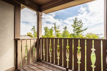 A balcony with a view of a blue sky and trees