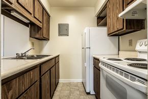Indianapolis apartment for rent - a kitchen with white appliances and wooden cabinets and a white refrigerator at Scarborough Lake Apartments, Indianapolis, IN, 46254