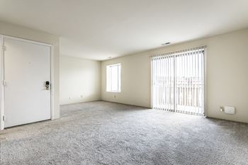 A room with a white door and a window with blinds