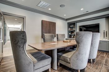 A modern dining room with a wooden table and grey chairs.