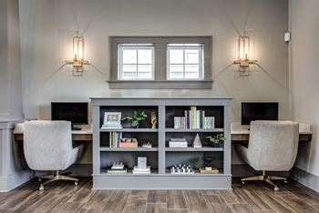 A modern home office with a desk, chair, and bookshelf.