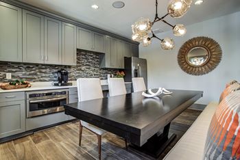 A modern kitchen with a black table and white chairs.