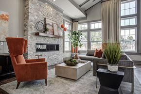 St. Charles apartment for rent - A living room with a fireplace and a chair. at River Crossing Apartments, St. Charles, 63303