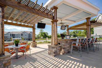 A patio with a table and chairs under a roof.