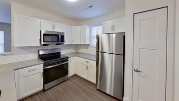 Athens apartment for rent - a kitchen with stainless steel appliances and white cabinets