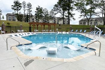A large swimming pool with houses in the background  