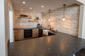 Wixom apartment for rent - A kitchen with a stone wall and a black counter top.