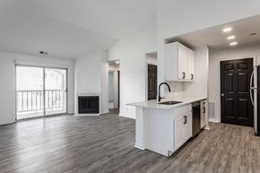 Indianapolis apartment for rent - A spacious kitchen with white cabinets and a black door. at Sundance Apartments, Indianapolis, IN