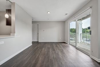 A room with a sliding glass door leading to a balcony.