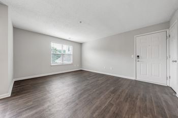 A room with wooden flooring and white walls.