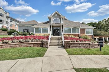 A house with a front yard and a sign that says 