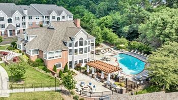 A large building with a pool in front of it.