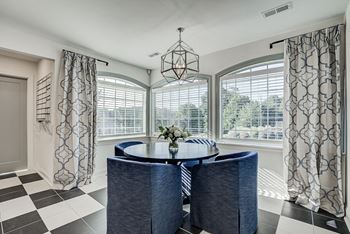 A dining room with a round table and chairs.