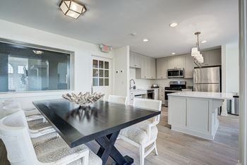 A modern kitchen with a dining table and chairs.