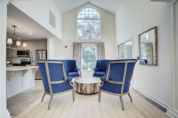 A living room with a blue chair and a coffee table.