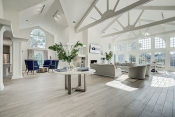 A spacious living room with a large table and chairs.