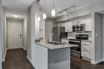 A modern kitchen with a large island and stainless steel appliances.