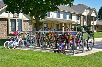 A row of bicycles are parked in front of a building