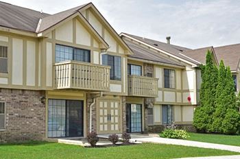 A building with two balconies and a sidewalk in front of it