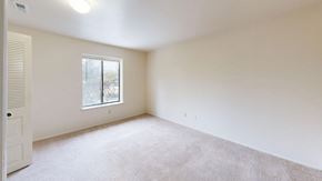 Lansing apartment for rent - spacious bedroom with a large window and carpet at Trappers Cove Apartments, Michigan, 48910