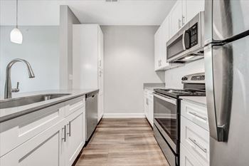 A modern kitchen with stainless steel appliances and white cabinets.