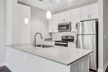 A modern kitchen with stainless steel appliances and white cabinets.