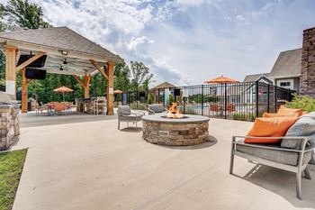 A patio with a fire pit and seating area.