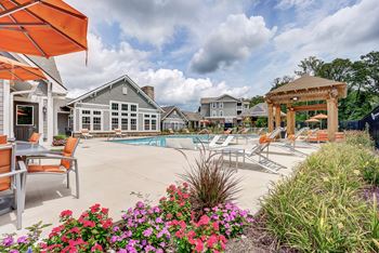 A pool area with a table and chairs and a gazebo.