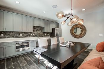 A modern kitchen with a black table and white chairs.