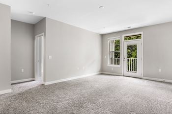 A room with grey carpet and white walls.