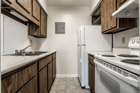 Evansville apartment for rent - a kitchen with white appliances and wooden cabinets and a white refrigerator at The Timbers Apartments, Evansville, IN