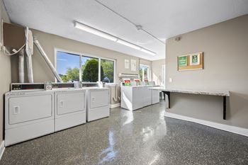 A clean, empty laundromat with washers and dryers