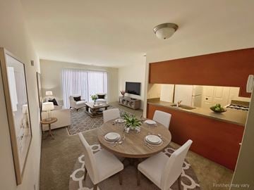 Wixom apartment for rent - a dining room and living room in a hotel room with a table and chairs