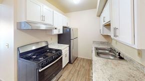 Portage apartment for rent - a renovated kitchen with stainless steel appliances and white cabinets at Walnut Trail Apartments in Portage, MI 49002
